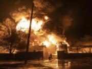 FILE - Firefighters extinguish a fire after a Russian attack on a residential neighborhood in Kharkiv, Ukraine Feb. 10, 2024. A new poll from The Associated Press-NORC Center for Public Affairs Research finds that U.S. adults have become fractured along party lines in their support for military aid for Ukraine.