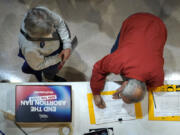 FILE - A residents places his signature on a petition during Missourians for Constitutionals Freedom kick-off petition drive, Feb. 6, 2024 in Kansas City, Mo. Abortion rights advocates are trying to get initiatives to protect reproductive on the ballot in several states this year, and one major difference has emerged in their proposed language &mdash; whether to include mental health as an exception.