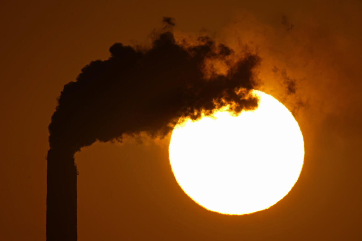 FILE - Emissions rise from the smokestacks at the Jeffrey Energy Center coal power plant as the suns sets Sept. 18, 2021, near Emmett, Kan. The Biden administration is setting tougher standards for deadly soot pollution, saying that reducing fine particle matter from tailpipes, smokestacks and other industrial sources could prevent thousands of premature deaths a year.