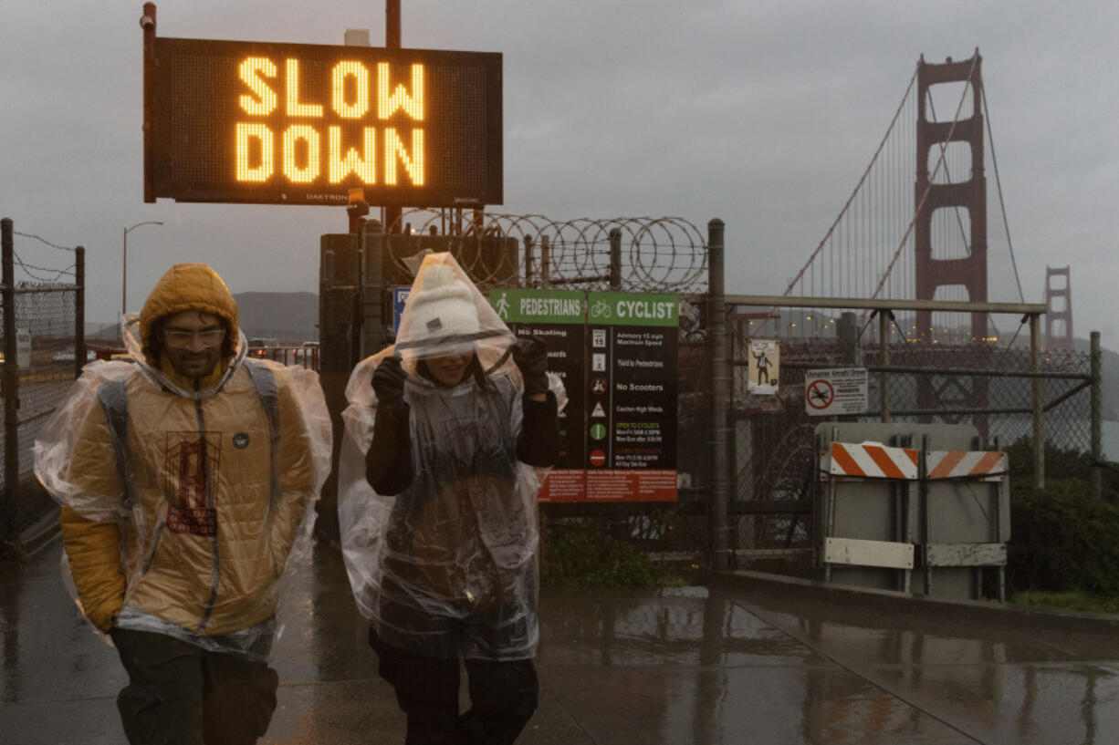 Samarth Jadhav, left, and Parvin Aktar visit the Golden Gate Bridge while on a trip from India during a rain storm in San Francisco on Wednesday, Jan. 31, 2024.