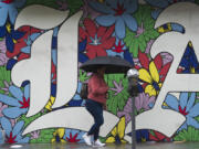 A woman walk under the rain in Los Angeles, Monday, Feb. 19, 2024.