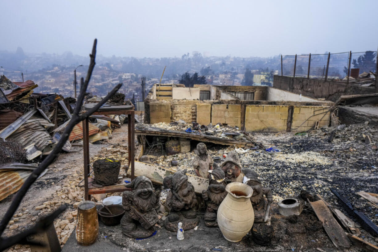 Garden gnomes are lined up in front of homes that were burnt when forest fires reached El Olivar neighborhood in Vina del Mar, Chile, Monday, Feb. 5, 2024. Areas around Vina del Mar were among the hardest-hit by fires that broke out in central Chile three day earlier, resulting in the deaths of more than a hundred people.