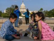 FILE - Members of the Safi family, who were evacuated from Afghanistan and are trying to make a new life in the U.S. while in immigration limbo, celebrate Eid by taking family photographs on the National Mall, May 3, 2022, near the U.S. Capitol in Washington. Growing opposition to the Senate border package once again poses a risk to the more than 76,000 Afghans who worked alongside U.S. soldiers in America&rsquo;s longest war, and who are currently living in the U.S. in immigration uncertainty as a result of years of congressional inaction.