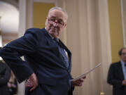 Senate Majority Leader Chuck Schumer, D-N.Y., looks over his notes before speaking reporters following a Democratic caucus meeting, at the Capitol in Washington, Wednesday, Jan. 31, 2024. (AP Photo/J.