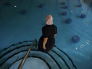 An Amish woman from Ohio wades into a pool with BioHealing generator canisters at Tesla Wellness Hotel and MedBed Center on Wednesday, Nov. 15, 2023, in Butler, Pa. The company claims the canisters exude &ldquo;life force energy,&rdquo; or biophotons. Testimonials from the company&rsquo;s patients speak to the device&rsquo;s power to treat cancer, dementia, chronic pain, and even broken bones.