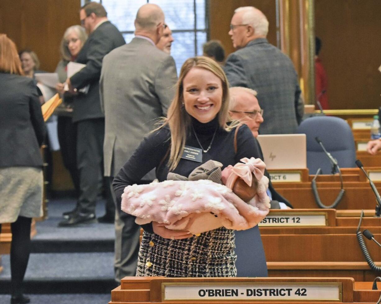 FILE - Rep. Emily O&rsquo;Brien R-Grand Forks carries daughter Jolene Green, 3 weeks, into the House chamber, Dec. 6, 2022, in Bismarck, N.D. Last year, the state representative helped persuade her colleagues to approve $66 million in child care spending proposed by Gov. Doug Burnum, a Republican. O&rsquo;Brien argued it could help the state&rsquo;s workforce shortage by helping more parents go to work.