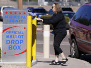 FILE - A voter places a ballot in an election voting drop box in Mesa, Ariz., Oct. 28, 2022. According to a bipartisan report released Tuesday, Feb. 6, 2024, that calls for greater transparency and steps to make voting easier, a &ldquo;tumultuous period of domestic unrest&rdquo; combined with a complicated and highly decentralized election system has led to a loss of faith in election results among some in the U.S. (AP Photo/Ross D.