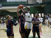 Maya Calhoun (21) of Evergreen has her shot blocked by Dream Mika (33) of Eastside Catholic in a Class 3A state playoff girls basketball game at Evergreen High School on Tuesday, Feb. 20, 2024.