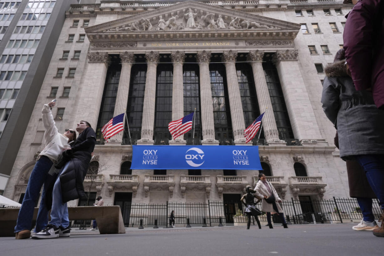 Tourists pose for photographs outside of the New York Stock Exchange, Tuesday, Feb. 27, 2024, in New York.