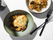 This image released by Milk Street shows a recipe for cheese baked farro with kale and tomatoes.