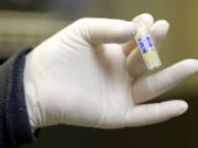 n this Tuesday, Oct. 2, 2018 photo, a lab worker holds a vial of frozen sperm at a fertility clinic in Fort Myers, Fla.