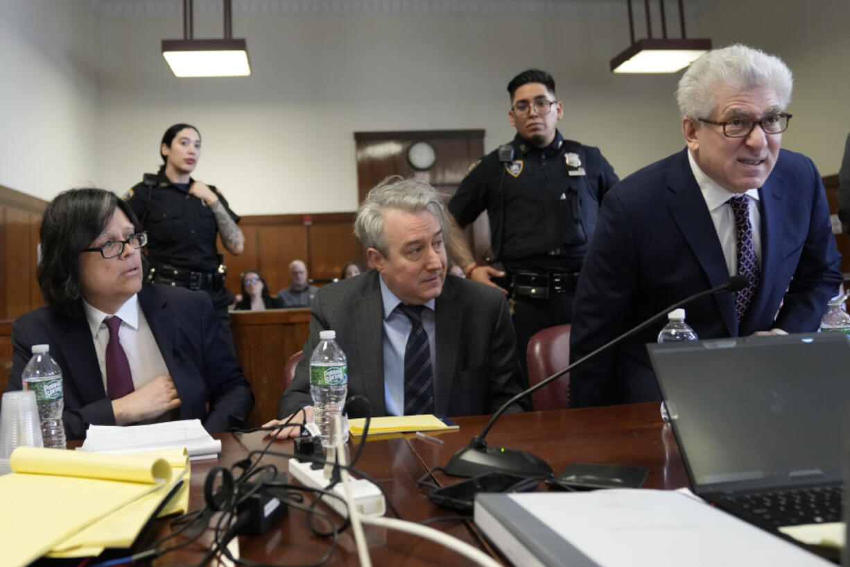 Defendants memorabilia seller Edward Kosinski, left, former Rock &amp; Roll Hall of Fame curator Craig Inciardi, center, and rare-book dealer Glenn Horowitz take a seat at the defense table in Supreme Court, Thursday, Feb. 22, 2024, in New York. A judge in New York will continue hearing testimony today in a criminal case involving ownership of the handwritten lyrics for the songs on the &quot;Hotel California&quot; album by The Eagles.