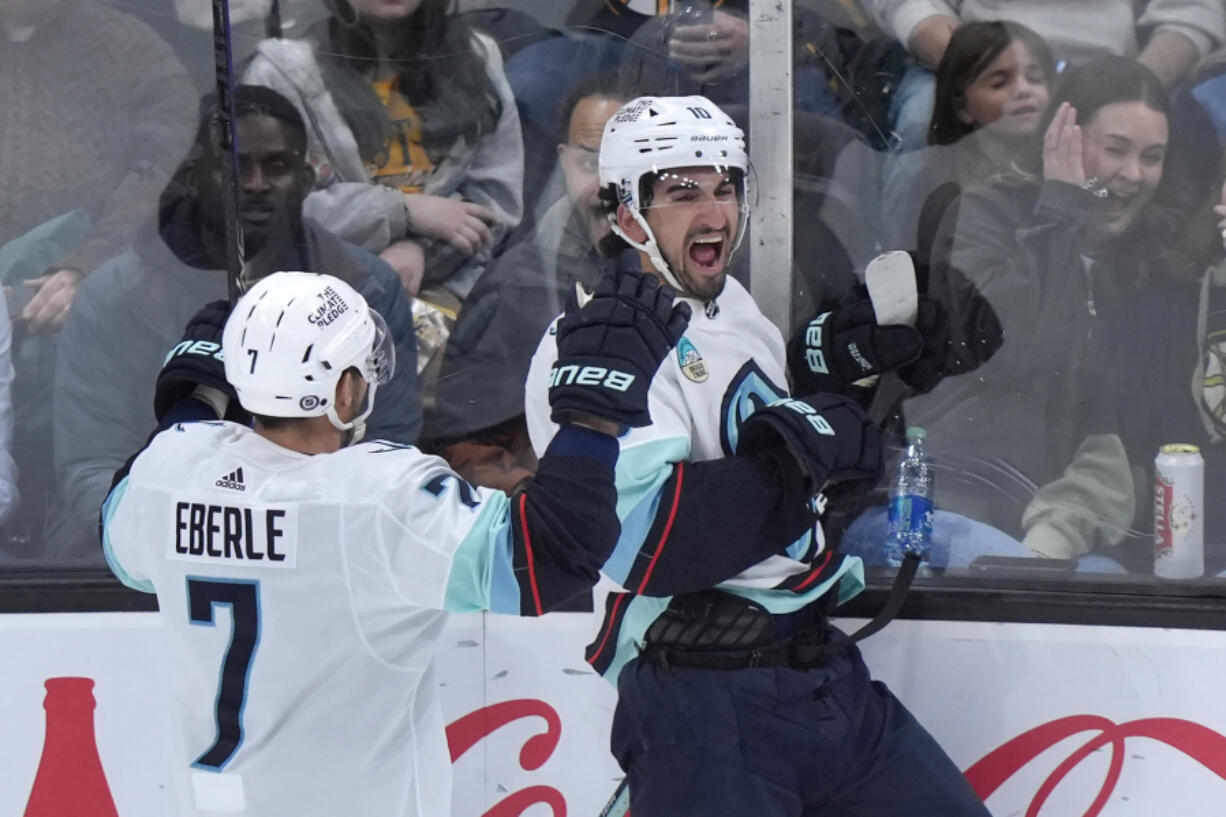 Seattle Kraken center Matty Beniers, right, celebrates with right wing Jordan Eberle after scoring against the Boston Bruins during the third period of an NHL hockey game Thursday, Feb. 15, 2024, in Boston.