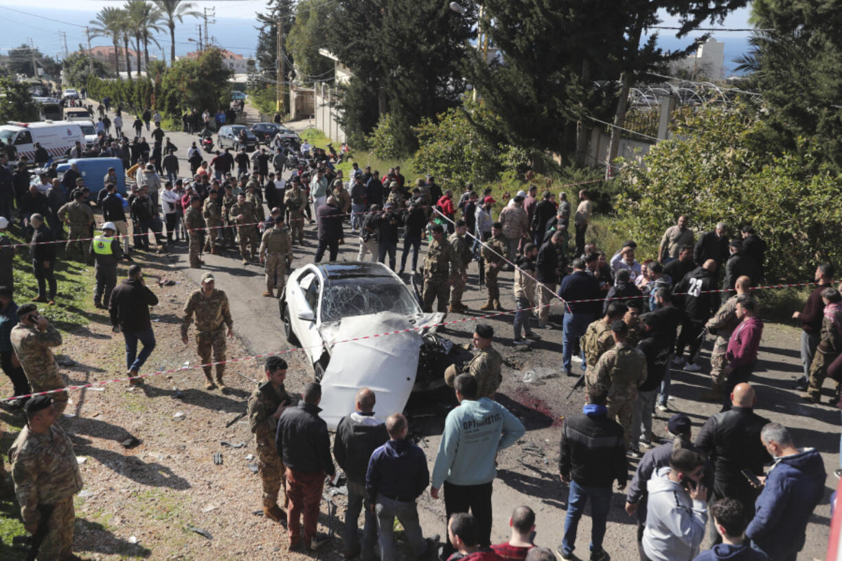 Lebanese army soldiers gather around a damaged car near the coastal town of Jadra, south Lebanon, Saturday, Feb. 10, 2024. An apparent Israeli drone strike hit a car near Lebanon&#039;s southern port city of Sidon Saturday killing at least two people and wounded others, security officials said.