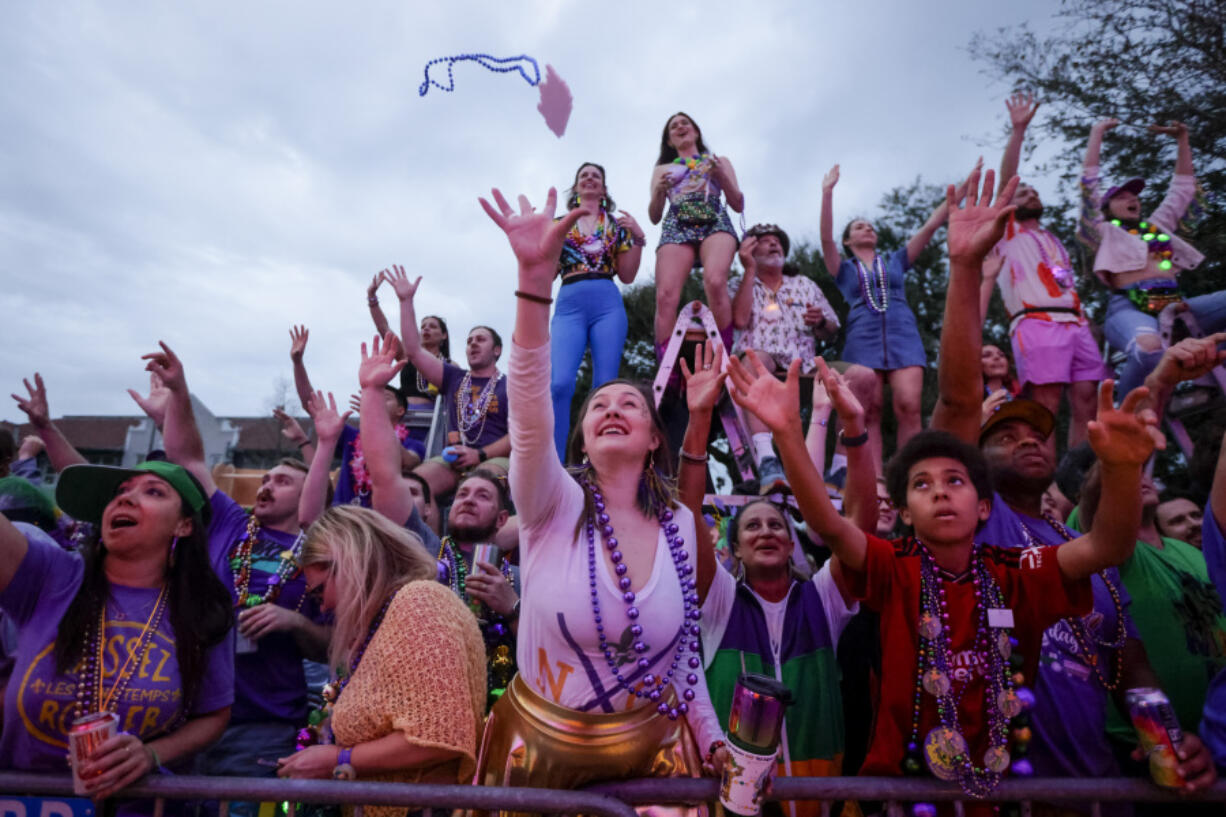 Revelers reach for trinkets as Endymion rolls in New Orleans, Saturday, Feb. 10, 2024, to the theme, &quot;Silents are Golden.&quot; Sydney Raymond reigned as queen and Andrew Morris Bahary as king and over 3,200 riders on 37 floats. The parade was dedicated to Endymion founder and captain, the late Ed Muniz, who helmed the krewe for 57 years, the longest-serving captain in Mardi Gras history.