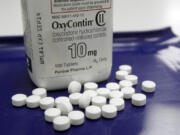 FILE - In this Feb. 19, 2013 file photo, OxyContin pills are arranged for a photo at a pharmacy in Montpelier, Vt. Companies and U.S. government entities have agreed to settlements of lawsuits over the toll of opioids totaling more than $50 billion.