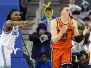 Oregon forward Tyler Bilodeau, right, reacts after being called for traveling as UCLA guard Dylan Andrews gestures during the second half of an NCAA college basketball game Thursday, Feb. 1, 2024, in Los Angeles. (AP Photo/Mark J.