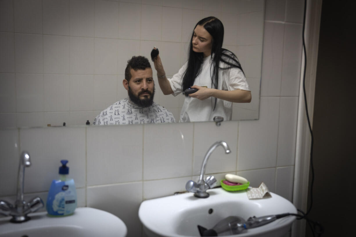 A barber cuts the hair of Checho, 32, a wounded professional soldier from Medell&iacute;n, Colombia, in a hospital in Ukraine on Wednesday, Dec. 20, 2023. Checho joined the Ukrainian armed forces to help  fight Russia. After two years of war, Ukraine is looking for ways to replenish its depleted ranks, and the Colombian army volunteers are a welcome addition.