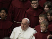 Pope Francis poses for photos with the young members of a chorus at the end of his weekly general audience in the Paul VI Hall, at the Vatican, Wednesday, Feb. 28, 2024.