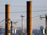 FILE - The Space Needle is seen in view of still-standing but now defunct stacks at a steel plant in Seattle on Feb. 25, 2016. A conservative-backed effort to repeal Washington state&#039;s landmark carbon pricing program and tax on the sale of stocks and bonds is putting the budget into limbo, with billions of dollars at stake and just days left in this year&#039;s Legislative session.