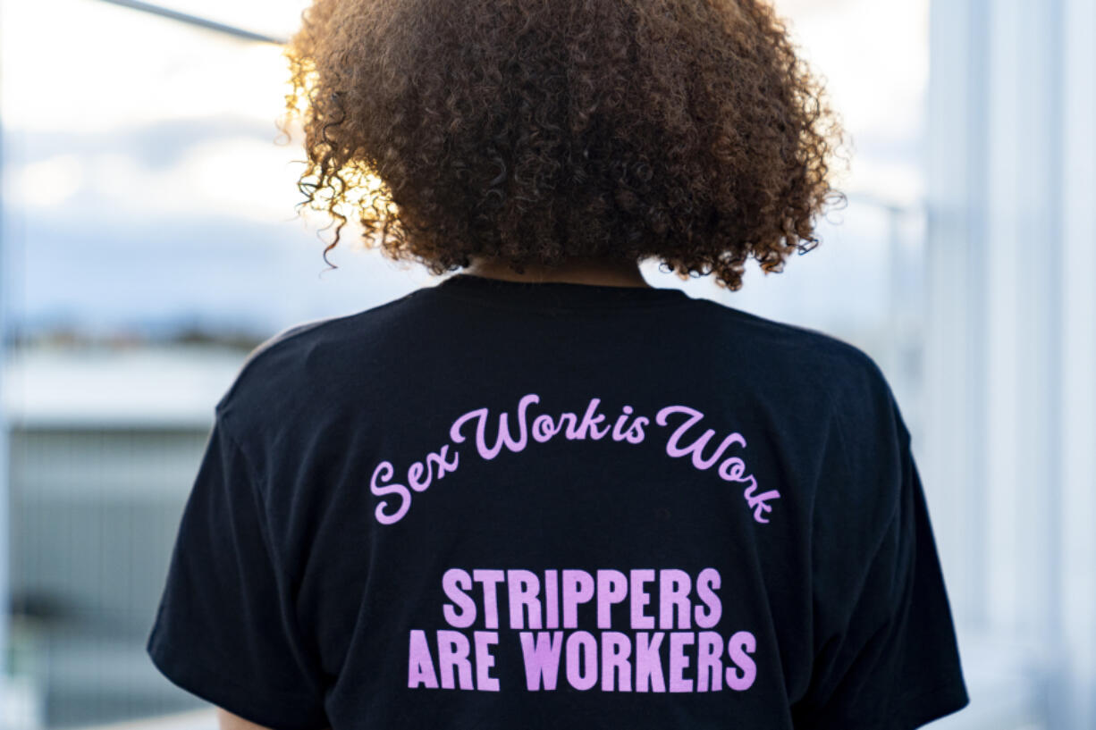 Andrea, no last name given, who works as a stripper in Seattle area clubs, poses for a portrait at her apartment, Thursday, Feb. 1, 2024, in Seattle. Andrea is among those fighting for bills to pass in the state Legislature that would expand statewide protections to workers, like having a security guard at each club, keypad codes to enter dressing rooms and de-escalation training.