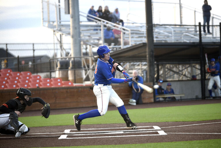 Ridgefield's Liam Ostrom (14) makes contact on a pitch during a season-opening, non-league baseball game against Battle Ground on Friday, March 8, 2024, at Ridgefield Outdoor Recreation Complex. The Spudders claimed a 4-3 win on a walk-off sacrifice fly in the seventh inning.