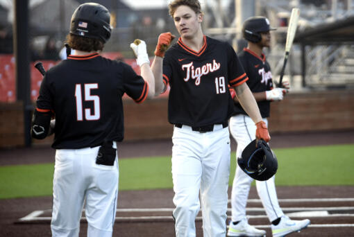 Battle Ground Jackson Hotchkiss (19) fist bumps teammate Keegan Moffatt (15) after Hotchkiss hit a solo home run during a season-opening, non-league baseball game against Ridgefield on Friday, March 8, 2024, at Ridgefield Outdoor Recreation Complex. (Will Denner/The Columbian)