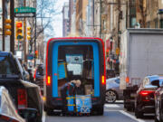 An Amazon delivery person takes packages out of her truck on Chestnut Street in Center City. Some Philadelphia consumers say they can&rsquo;t break their Amazon shopping habit, despite having ethical concerns with the company and its owner, billionaire Jeff Bezos. (Alejandro A.