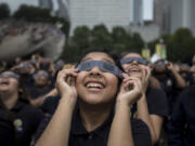 Students from Muchin College Prep react as the solar eclipse emerges from behind clouds in Millennium Park in Chicago on Aug. 21, 2017.