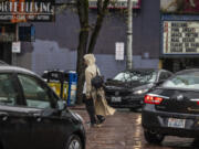 A pedestrian walks through moving traffic in downtown Seattle on Wednesday, Feb. 28, 2024.