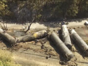 Crumpled oil tankers lie beside the railroad tracks June 6, 2016, after a fiery train derailment that prompted evacuations from the tiny Columbia River Gorge town of Mosier, Ore.