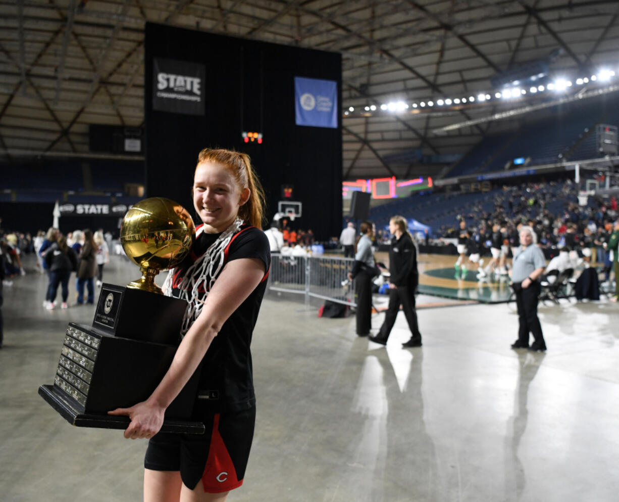 Camas senior Addison Harris smiles as she leaves the floor of the Tacoma Dome with the state championship trophy  after the Papermakers&rsquo; 57-41 win against Gonzaga Prep.