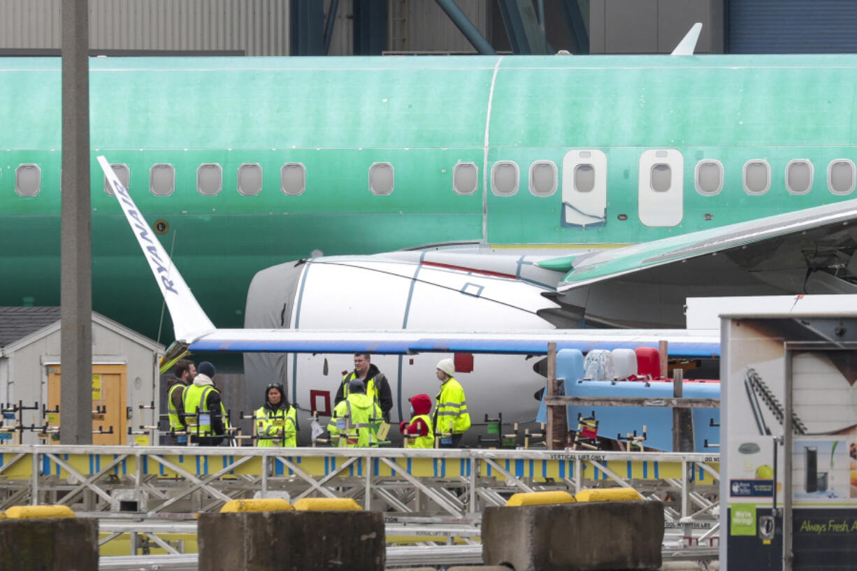 Workers are pictured next to an unpainted 737 aircraft and unattached wing with the Ryanair logo as Boeing&rsquo;s 737 factory teams hold the first day of a &ldquo;Quality Stand Down&rdquo; for the 737 program at Boeing&rsquo;s factory in Renton, Washington on Jan. 25, 2024.