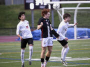 Union's Caleb Putney, center, goes up for a header between Camas' Shiven Friedeman, left, and Travis O'Hara during a 4A Greater St. Helens League boys soccer match on Thursday, March 28, 2024, at Union High School.