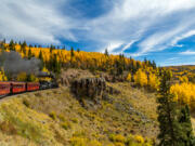 A Cumbres &amp; Toltec steam locomotive heads up a mountain with a passenger train while traveling through the San Juan National Forest on a trip from Chama, N.M., through a beautiful scenic route ending in Antonito, Colo.