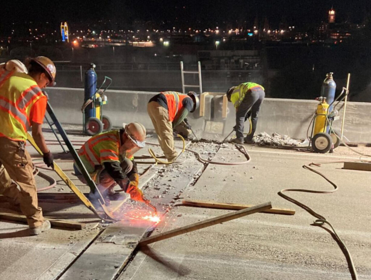 Workers cut away an old expansion joint on Interstate 5 in Seattle, during 2022.