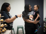 Taylor Richardson, left, smiles as her mother Ruth Richardson, executive director of Planned Parenthood North Central States, center, holds her granddaughter, Trinity, at the little girl&rsquo;s birthday party on Feb. 3. A former Minnesota legislator, Ruth Richardson says she sees health equity as central to the future of Planned Parenthood.