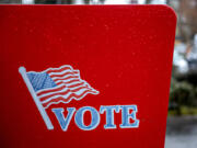 Voters drop primary ballots into the ballot box in downtown Vancouver.