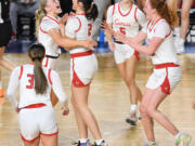 Camas players hug junior Kendall Mairs, center, after Mairs made a basket while being fouled Friday, March 1, 2024, during the Papermakers’ 60-48 win against Sumner in a WIAA 4A State Basketball semifinal game at the Tacoma Dome.