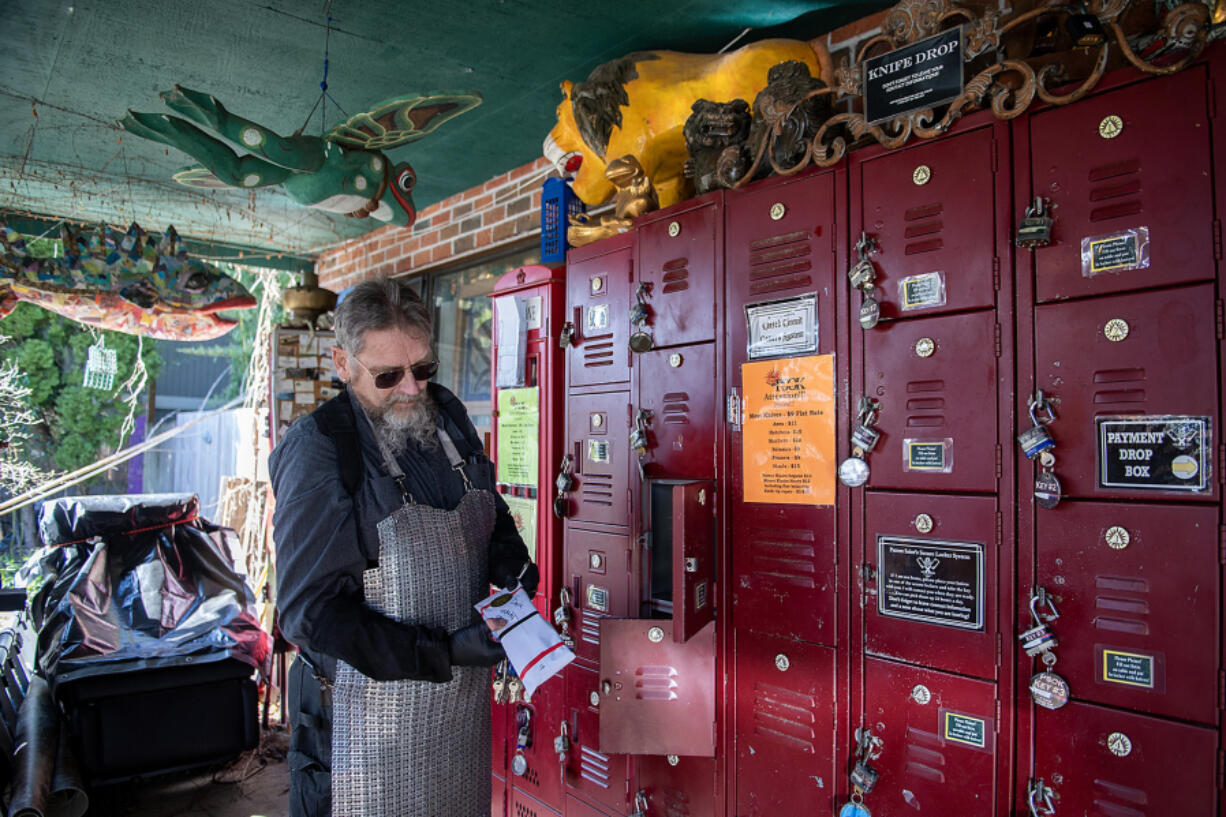 Eliot Smith, aka the Patron Saint of Knives, looks over a customer&rsquo;s order at the knife drop outside his Vancouver home workshop.