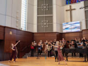 Dancers Anna Chapin, left, 13, and Keira Wachter, right, 12, rehearse their moves while the Reprise Choir practices &ldquo;She Was Dancing,&rdquo; a song in the upcoming &ldquo;Voice of Washington&rdquo; program.