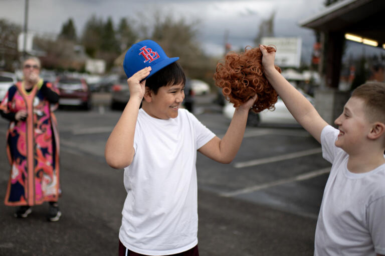 Kids try out the iconic Mrs. Roper wig for themselves while crossing paths with some of the pub crawlers in downtown Battle Ground on Saturday evening, March 23, 2024.