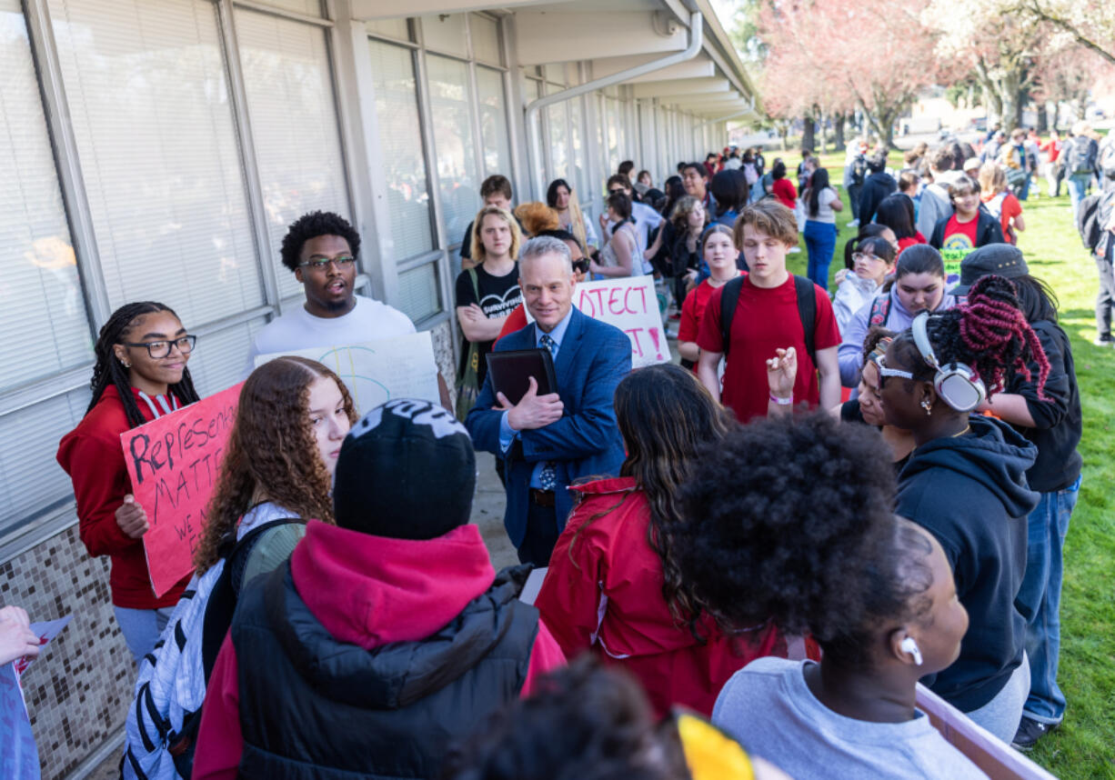 Vancouver Public Schools superintendent Jeff Snell, center, talks to Fort Vancouver High School students on Tuesday during the students&rsquo; walk-out to protest the district&rsquo;s cuts to 262 staff positions next year.