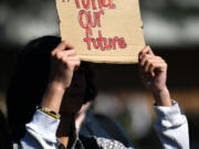 A Fort Vancouver High School student holds up a sign Tuesday during a walk-out to protest budget cuts affecting 262 staff positions next year.