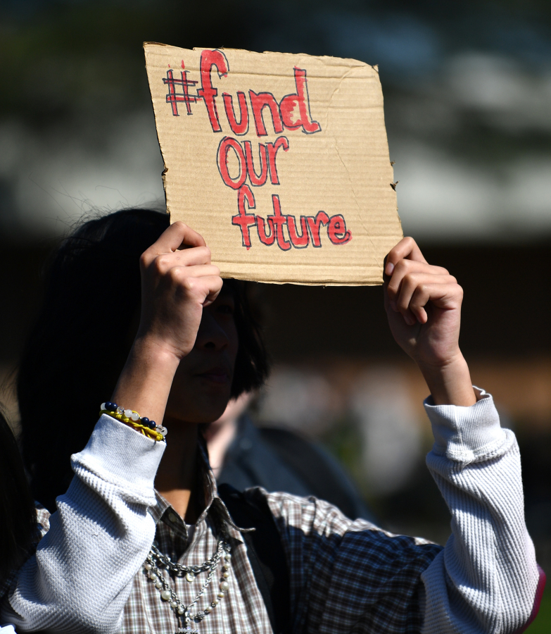 A Fort Vancouver High School student holds up a sign Tuesday during a walk-out to protest budget cuts affecting 262 staff positions next year.