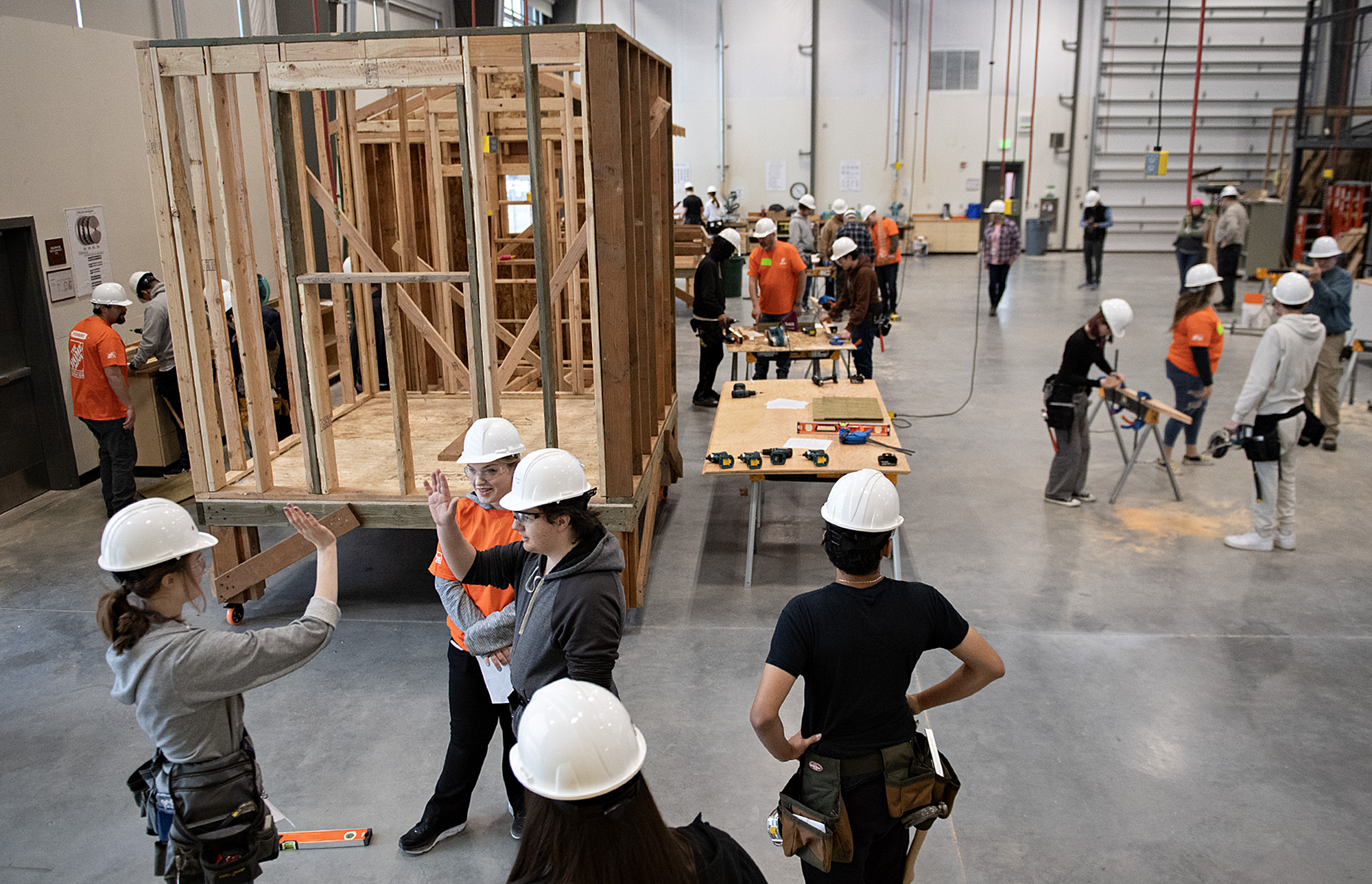 Evergreen High School sophomore Rue Rollins, 16, from left, celebrates a job well done with Trillium Allison from The Home Depot and classmate Domonick Good, 15, on Thursday morning, March 21, 2024. The volunteers taught the students building skills in hopes of encouraging them toward pursuing trade careers.