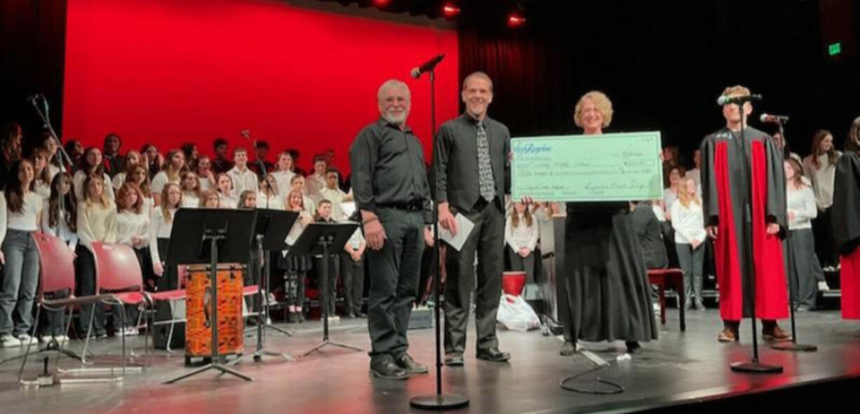 David Tripp, Reprise Choir Sings board president, Erik Edmondson, Liberty Middle School choir director, and Katie Hebner, Reprise Choir board member (holding the check).