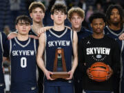 Skyview players stand for a photo with their sixth place trophy Saturday, March 2, 2024, following the Storm’s 69-47 loss to Kentwood in a WIAA State Basketball consolation game at the Tacoma Dome. The 2023-24 Storm matched the school’s highest ever finish from 2018.