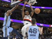 Portland Trail Blazers forward Jabari Walker (34) dunks between Memphis Grizzlies forward GG Jackson II, left, and guard John Konchar (46) in the second half of an NBA basketball game Saturday, March 2, 2024, in Memphis, Tenn.