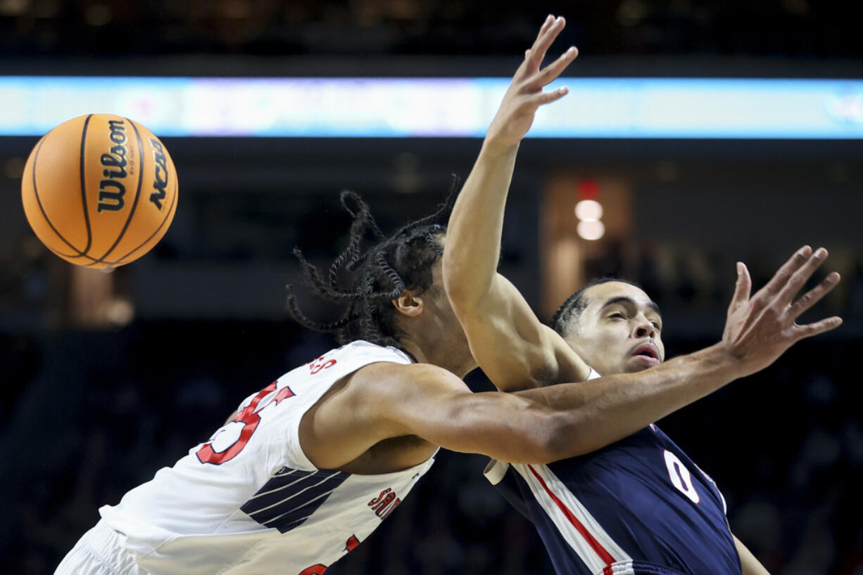 Saint Mary's forward Mason Forbes (25) and Gonzaga guard Ryan Nembhard (0) go after the ball during the first half of an NCAA college basketball game for the championship of the West Coast Conference men's tournament Tuesday, March 12, 2024, in Las Vegas.